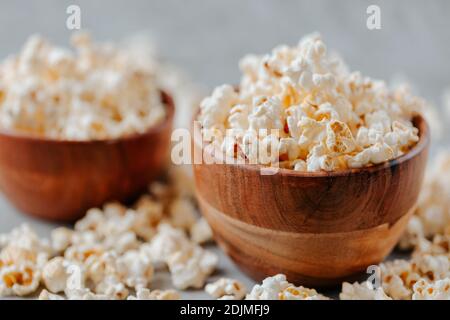 Two wooden bowls of popcorn on rustic grey table. Selective focus and copyspace for text. Concept of relax and time off. Stock Photo