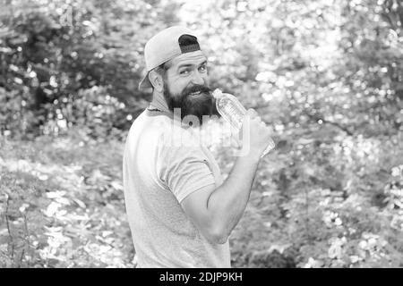 Hydrate Or Die. brutal hipster in forest. discover new places. time for picnic. guy drink water. mature bearded man in cap. summer camping vacation. man hipster hiking. male feel thirsty. Stock Photo