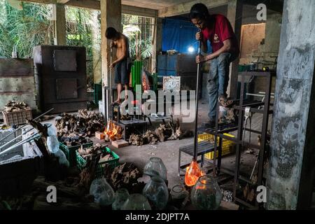 TEGALALANG/BALI-4 DEC 2020: A glazier is shaping hot glass which is done by blowing. Glass crafts in Ubud Bali became a favorite during the COVID-19 p Stock Photo