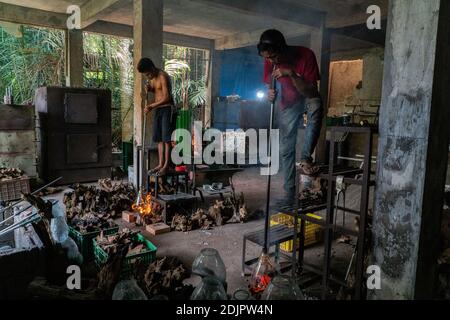 TEGALALANG/BALI-4 DEC 2020: A glazier is shaping hot glass which is done by blowing. Glass crafts in Ubud Bali became a favorite during the COVID-19 p Stock Photo