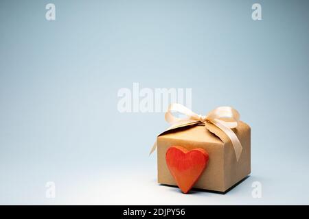Valentine's Day gift with Cream Ribbon Bow in Craft Cardboard Box with red wooden heart Stock Photo
