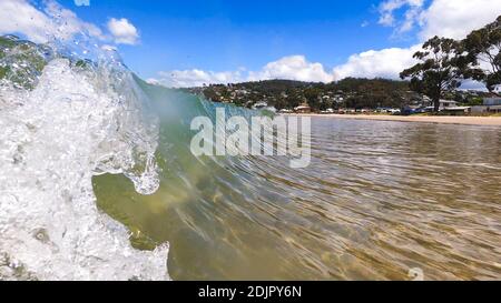 HOBART, TASMANIA - December 6th, 2020: waves crashing at the beach in the popular suburb of Kingston Beach in Suthern Tasmania on a sunny summer day Stock Photo