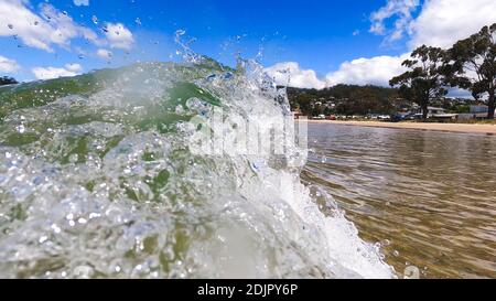 HOBART, TASMANIA - December 6th, 2020: waves crashing at the beach in the popular suburb of Kingston Beach in Suthern Tasmania on a sunny summer day Stock Photo