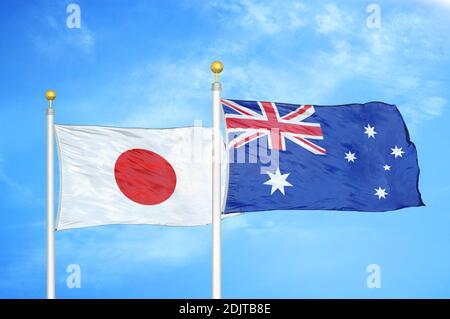 Japan and Australia two flags on flagpoles and blue cloudy sky Stock Photo