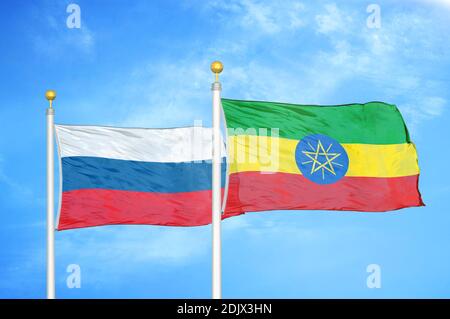 Russia and Ethiopia two flags on flagpoles and blue cloudy sky Stock Photo
