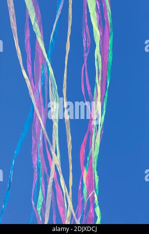 Rainbows of abstract moving lines, in vivid colors, formed by wrinkled fabrics that float lightly on a plain-colored background. Stock Photo