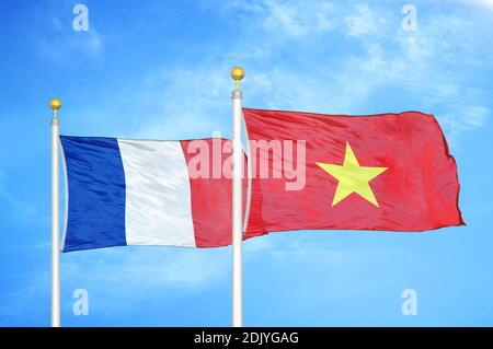 France and Vietnam two flags on flagpoles and blue cloudy sky Stock Photo