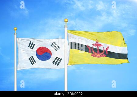 South Korea and Brunei two flags on flagpoles and blue cloudy sky Stock Photo