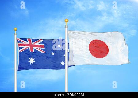 Australia and Japan two flags on flagpoles and blue cloudy sky Stock Photo