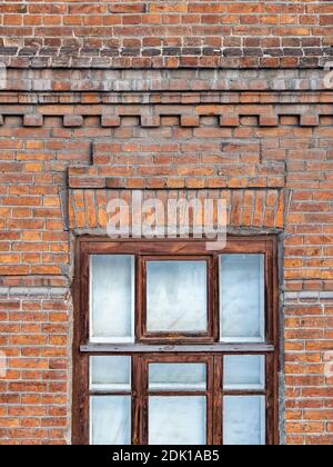 The window of the old mansion 19 century with brown bricks wall. Brick wall of an old 19th century building with window. Stock Photo