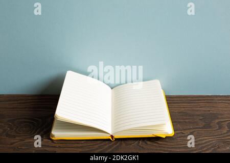 Open note book on wooden desk. sky blue background Stock Photo