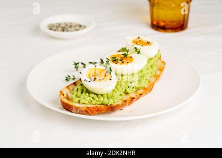 Avocado toast with toasted bread soft-boiled eggs with herbs Stock Photo