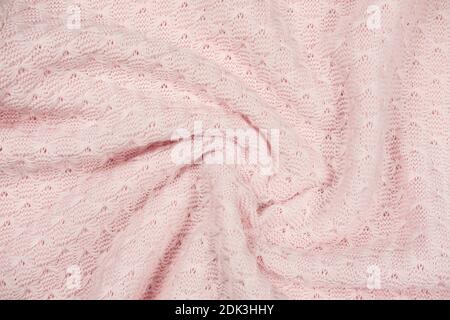 pink knitted fabric swirl. twisted soft sweater textured background. pink female textile. winter outfit cozy pullover. Stock Photo