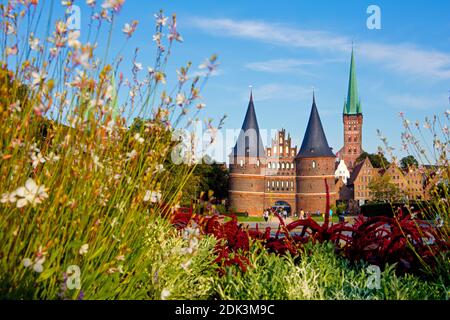 Germany, Schleswig-Holstein, Hanseatic City of Lübeck, View of the Holsten Gate, The brick building is also the city's landmark, In the background the old salt store and the tower of St, Petri Church, Stock Photo