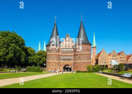 Germany, Schleswig-Holstein, Hanseatic City of Lübeck, View of the Holsten Gate, The brick building is also the city's landmark, In the background the old salt stores and the towers of the Marienkirche and St, Petri Church, Stock Photo