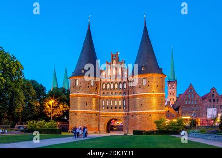 Germany, Schleswig-Holstein, Hanseatic City of Lübeck, view of the Holsten Gate, The brick building is also the city's landmark, In the background the old salt stores and the towers of the Marienkirche and St, Petri Church, Stock Photo