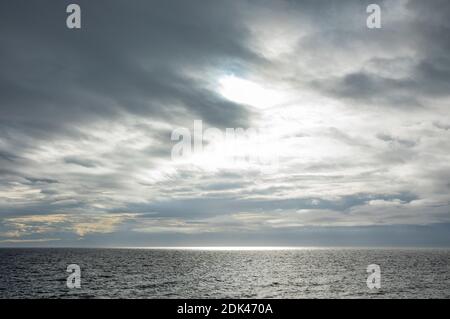 Sunlight breaking through the heavy cloud cover over the Strait of Juan de Fuca, as seen from San Juan Island, Washington, USA. Stock Photo