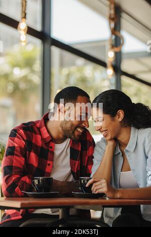 Loving couple at a coffee shop together. Smiling man and woman sitting at coffee shop. Stock Photo