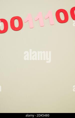 A vertical of red and pink binary codes on a white surface Stock Photo
