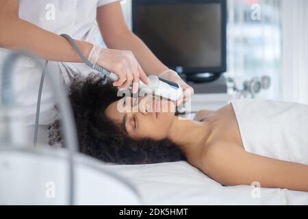 Beautician hands with apparatus and girl face Stock Photo