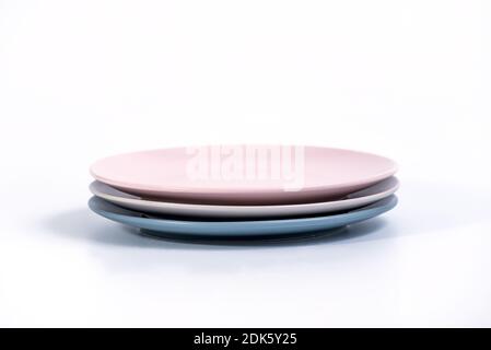 Stack of three colorful empty plates isolated on white background, side view. Navy Blue, Grey and Pink empty plates collection Stock Photo