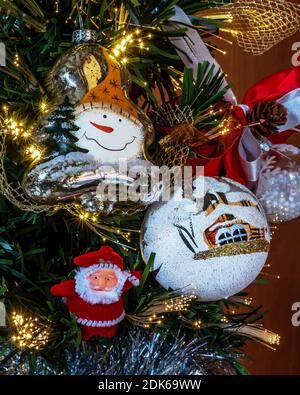 Close detail of the typical decorations of a Christmas tree with fairy lights Stock Photo