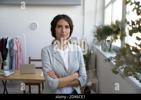 Happy lady skilled designer standing at workroom in confident pose Stock Photo
