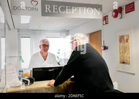 Senior man at reception in doctor's surgery Stock Photo