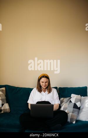 Woman on sofa using laptop Stock Photo