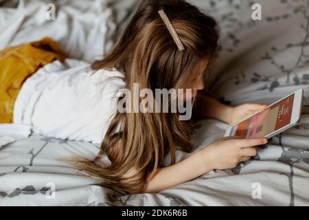 Girl on bed using table Stock Photo