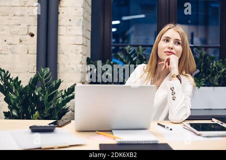 Pensive businesswoman working on laptop in office Stock Photo