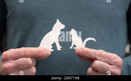 Man holding a paper dog and cat; Concept of pet insurance Stock Photo