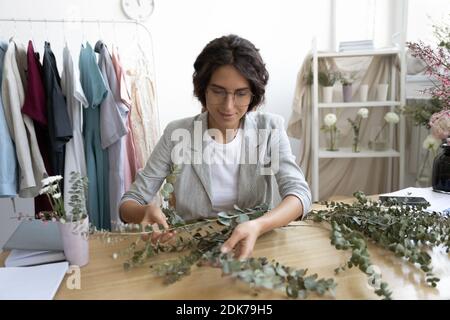 Young woman florist working on floral bunch by customer order Stock Photo
