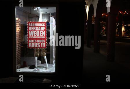 14 December 2020, Bavaria, Würzburg: A fashion store advertises a going out of business sale downtown. Photo: Karl-Josef Hildenbrand/dpa Stock Photo