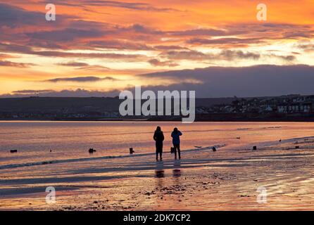 Portobello, Edinburgh, Scotland, UK. 15 December 2020. Fiery sky at sunrise for those taking a walk by the shore of the Firth of Forth. Credit: Arch White/Alamy Live News.