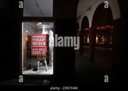 14 December 2020, Bavaria, Würzburg: A fashion store advertises a going out of business sale downtown. Photo: Karl-Josef Hildenbrand/dpa Stock Photo