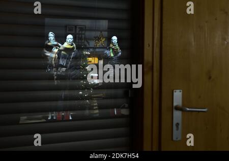 14 December 2020, Bavaria, Würzburg: Mannequins reflected in the window of a closed stall at the evening Christmas market. Photo: Karl-Josef Hildenbrand/dpa Stock Photo