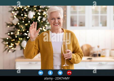 Positive mature lady celebrating New Year during isolation Stock Photo