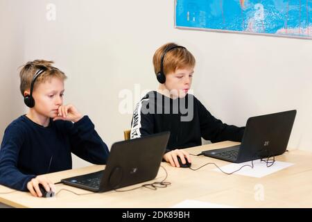 Boys in classroom using laptops Stock Photo