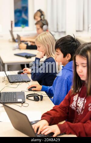 Children in classroom using laptops Stock Photo