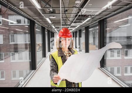 Female worker looking at blueprints Stock Photo