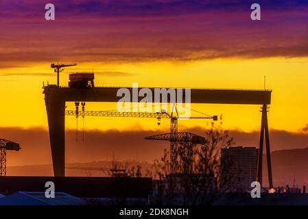 Sunset over Sampson, one of two giant gantry cranes at Harland & Wolff shipyard in Belfast, Northern Ireland, birthplace of Olympic & Titanic. Along w Stock Photo