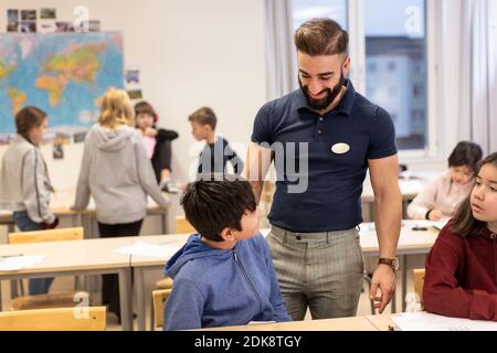Teacher with schoolboy in classroom Stock Photo
