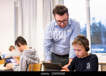 Teacher with schoolboy in classroom Stock Photo