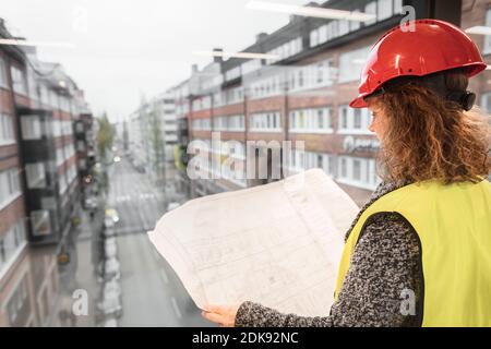 Female worker looking at blueprints Stock Photo