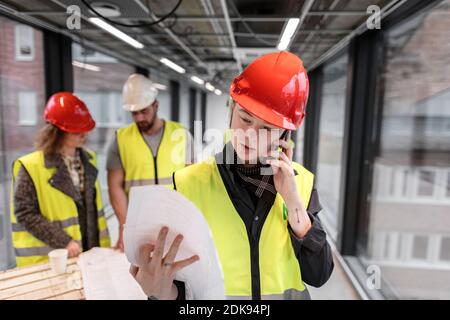 Female construction worker looking at blueprints Stock Photo
