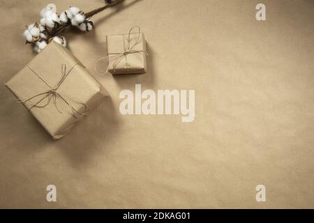 Two gift boxes wrapped in plain brown recycled paper with rope on brown background texture top view, present and recycle concept, copy space, space fo Stock Photo
