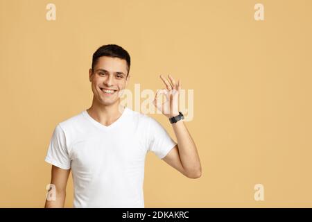 Successful man with gestures celebrating victory. Happy attractive young blogger shows sign okay Stock Photo