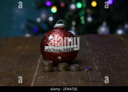 Merry Christmas. Christmas composition. Money box for Christmas money. Text on the box in German: Christmas money. Stock Photo