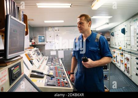 Marine Engineer working on radio communication at Engine Control room ECR Stock Photo